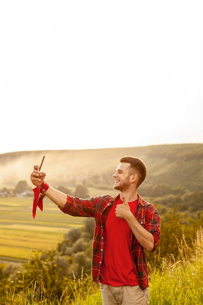 Foto gratuita hombre de alto ángulo en montaña tomando selfie