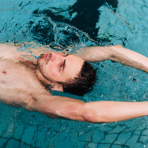 Hombre de alto ángulo nadando en la espalda