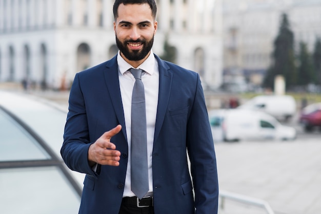 Hombre de alto ángulo preparado para estrecharle la mano