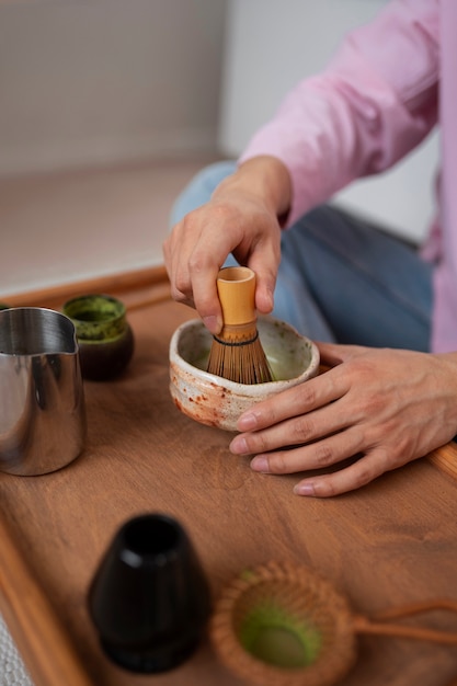 Foto gratuita hombre de alto ángulo preparando té matcha