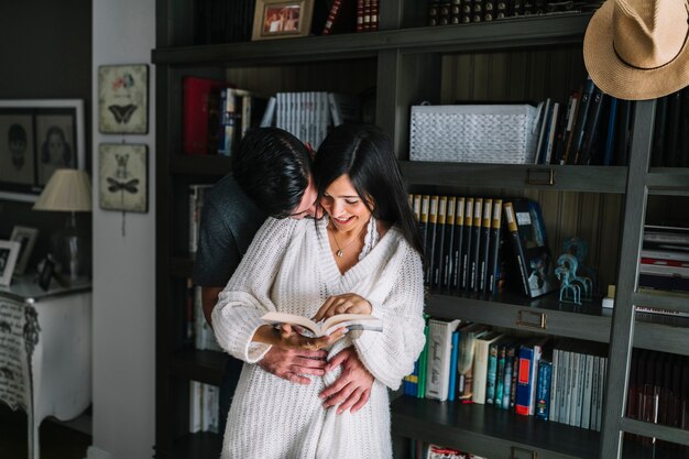 Hombre amando a su novia sosteniendo un libro abierto