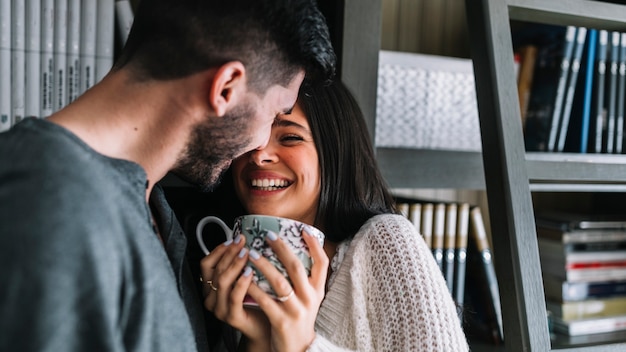 Hombre amante de su sonriente mujer sosteniendo la taza de café