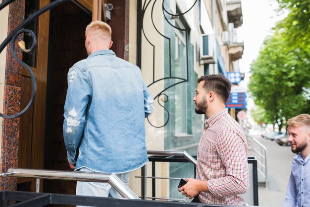 Hombre con amigos entrando en el restaurante