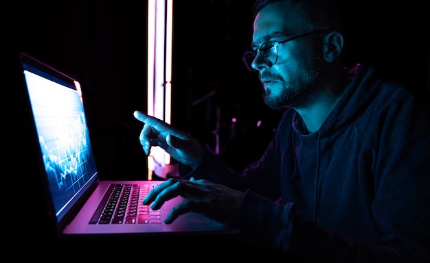 Un hombre analizando los gráficos del mercado de valores de datos financieros en una placa electrónica