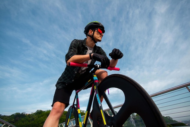 El hombre anda en bicicleta en el puente La imagen del ciclista en movimiento en el fondo de la mañana