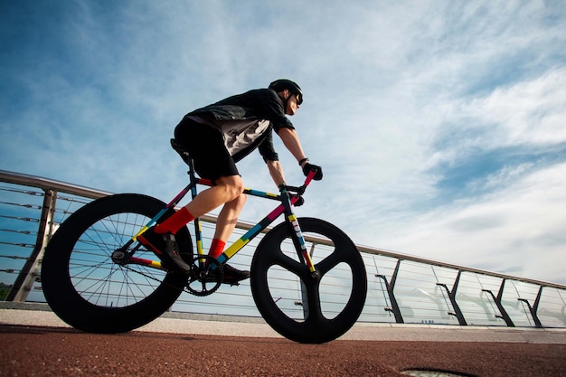 El hombre anda en bicicleta en el puente La imagen del ciclista en movimiento en el fondo de la mañana