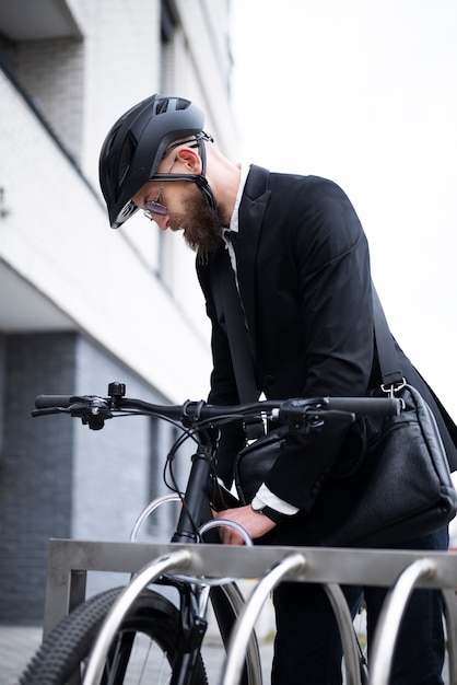 Foto gratuita hombre de ángulo bajo asegurando bicicleta