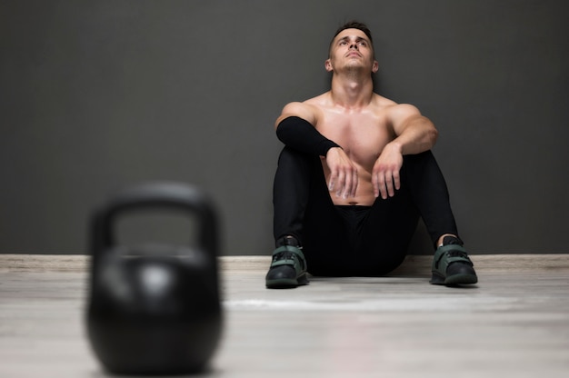 Hombre de ángulo bajo cansado de entrenamiento