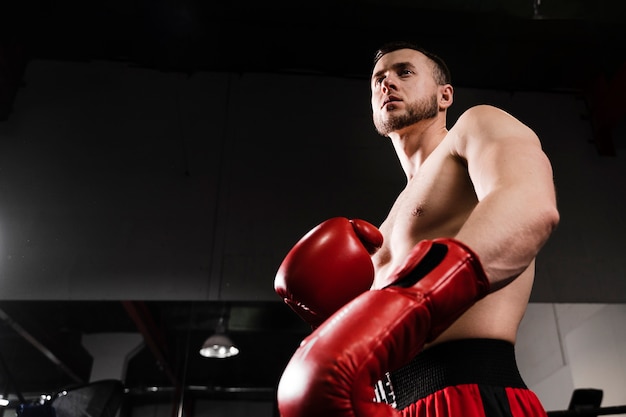 Hombre de ángulo bajo entrenando como boxeador