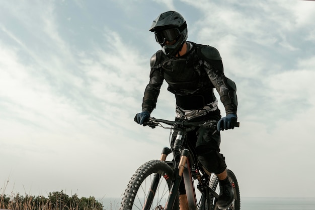 Foto gratuita hombre de ángulo bajo en equipo de ciclismo de montaña