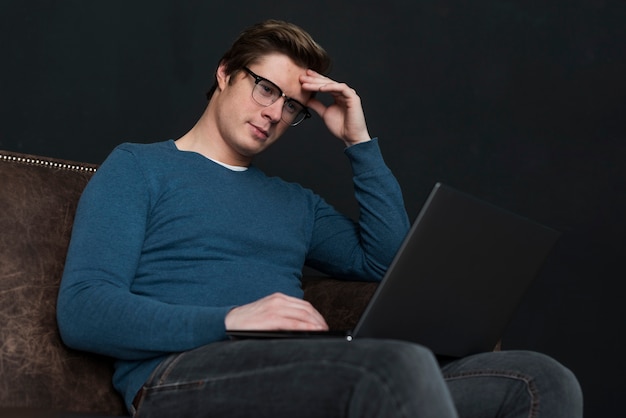 Foto gratuita hombre de ángulo bajo mirando en su computadora portátil