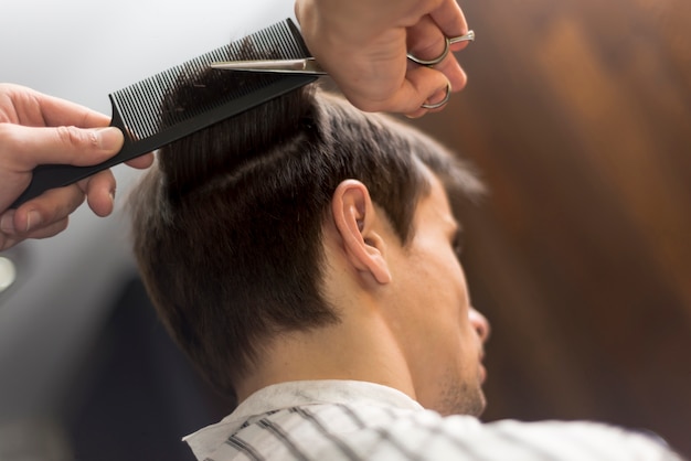 Hombre de ángulo bajo que consigue un corte de pelo