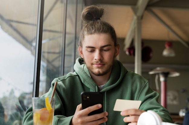 Foto gratuita hombre de ángulo bajo con smartphone