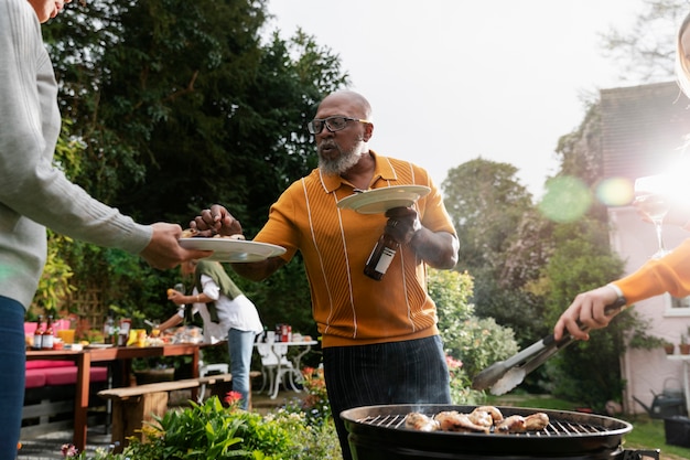 Foto gratuita hombre de ángulo bajo sosteniendo plato y bebida