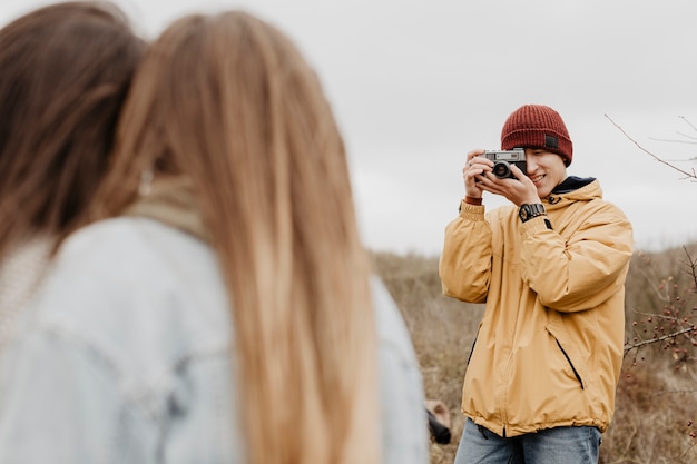 Foto gratuita hombre de ángulo bajo tomando fotos de mujeres