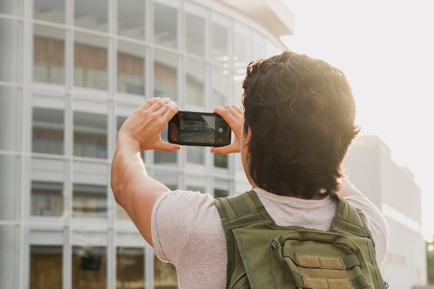 Hombre de ángulo bajo tomando fotos