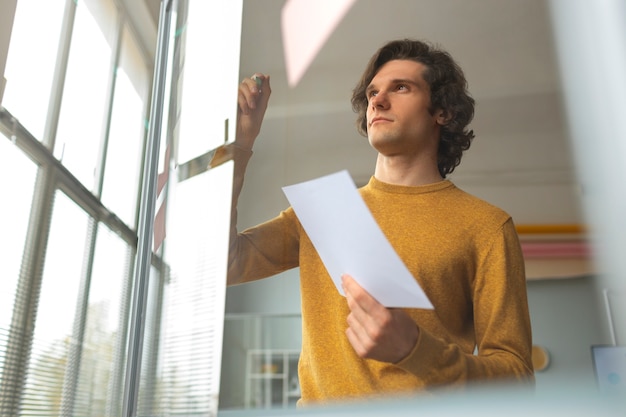 Foto gratuita hombre de ángulo bajo trabajando en la oficina