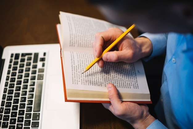 Hombre anónimo haciendo notas en el libro