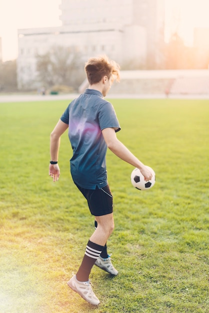 Hombre anónimo pateando la pelota