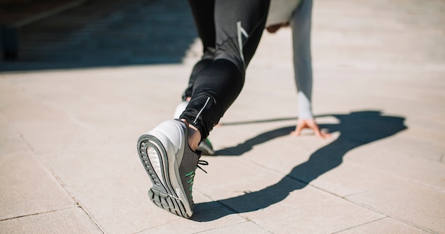 Foto gratuita hombre anónimo en ropa deportiva haciendo crouch start