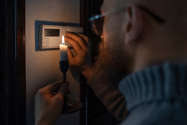 Foto gratuita hombre apagando el termostato durante la crisis energética