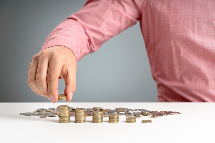 Foto gratuito hombre apilando monedas en el escritorio