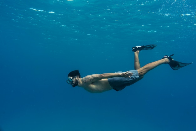 Foto gratuita hombre apnea con aletas bajo el agua