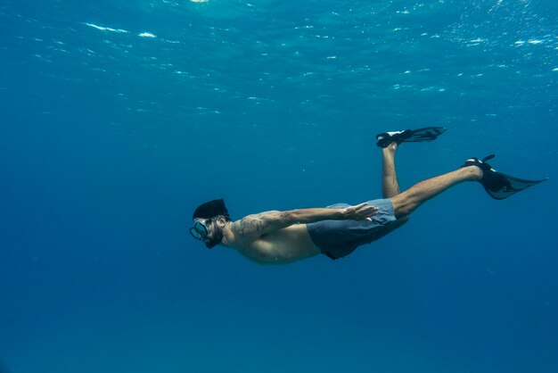 Hombre apnea con aletas bajo el agua