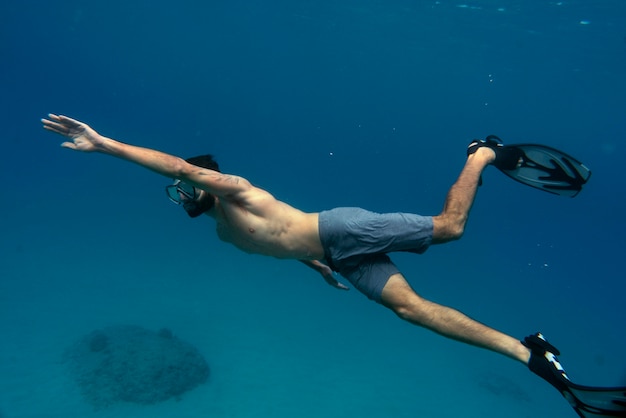 Foto gratuita hombre apnea con aletas bajo el agua