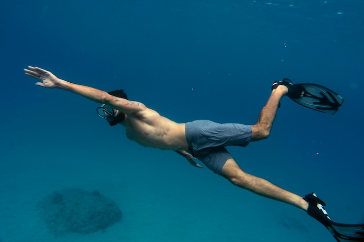 Foto gratuito hombre apnea con aletas bajo el agua