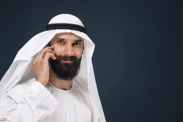 Hombre de Arabia Saudita en estudio azul oscuro