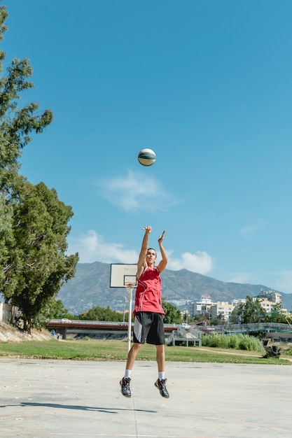 Un hombre arrojando baloncesto en el aire