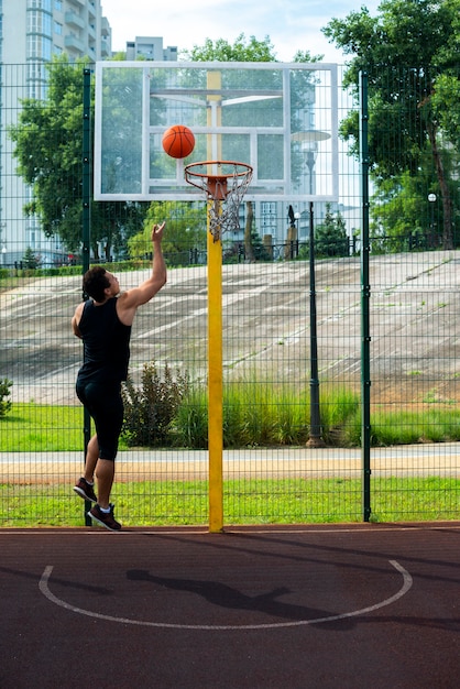 Foto gratuita hombre arrojando una pelota en una canasta