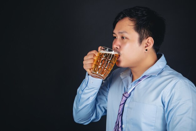 hombre asiático bebiendo una jarra de cerveza