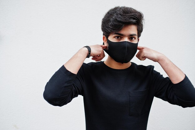El hombre asiático usa todo negro con máscara facial aislada en el fondo blanco