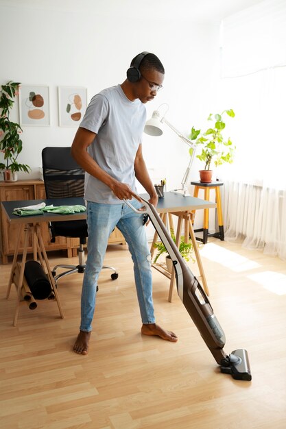 Hombre aspirando piso tiro completo