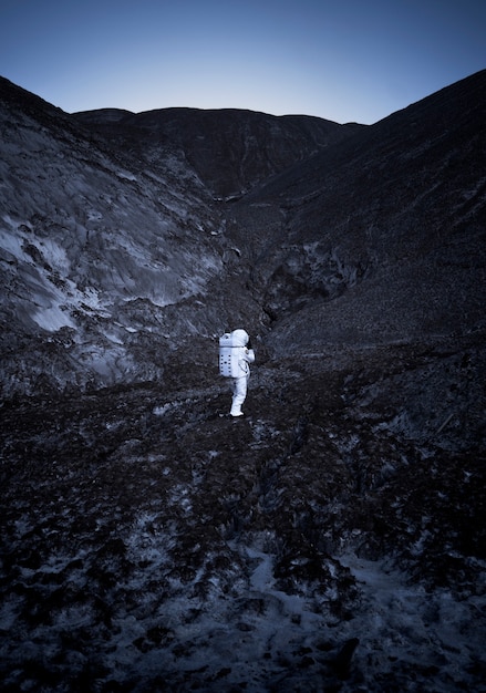 Hombre astronauta explorando de noche durante una misión espacial en un planeta desconocido