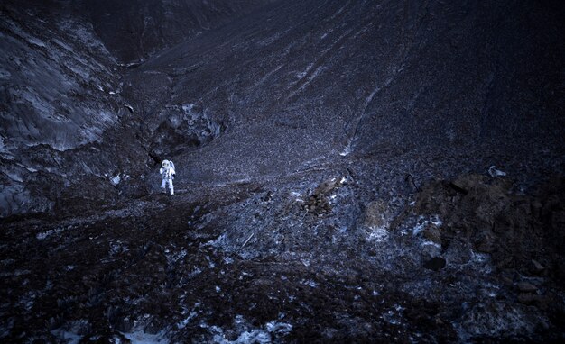 Hombre astronauta explorando de noche durante una misión espacial en un planeta desconocido