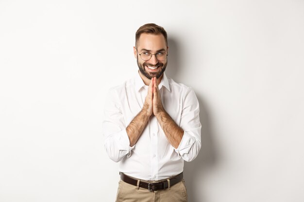 Hombre astuto y satisfecho que tiene una idea, frotándose las manos y tramando algo con cara de satisfacción