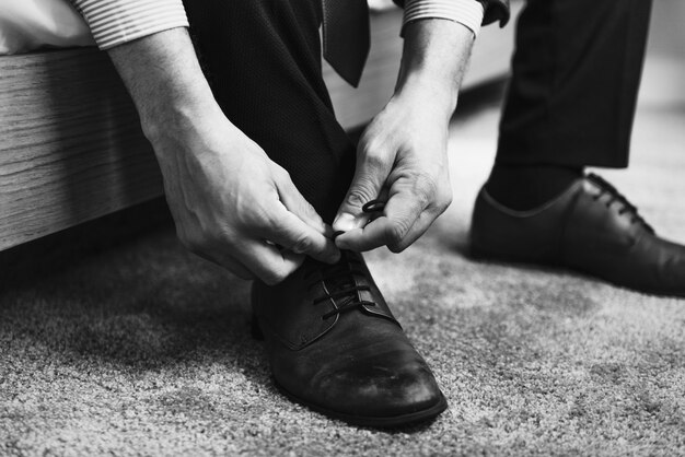 Un hombre atando cordones de zapatos