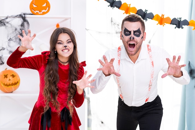 Foto gratuita hombre aterrador y niña en disfraces de halloween