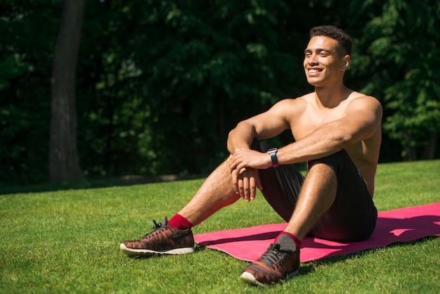 Foto gratuita hombre atlética practicando yoga al aire libre