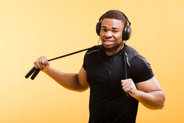 Hombre atlético con auriculares y saltar la cuerda