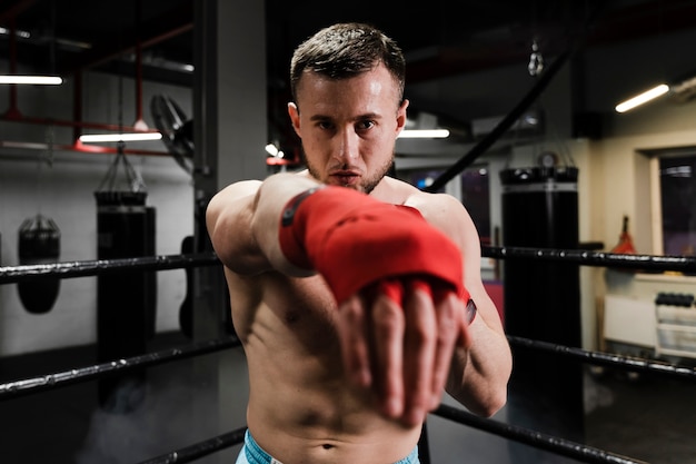 Hombre atlético entrenando en ring de boxeo