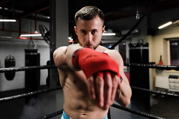 Hombre atlético entrenando en ring de boxeo