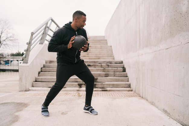 Hombre atlético haciendo ejercicio de pelota de pared.