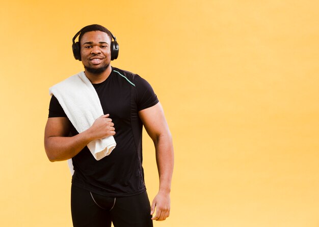 Foto gratuita hombre atlético posando en traje de gimnasio y toalla