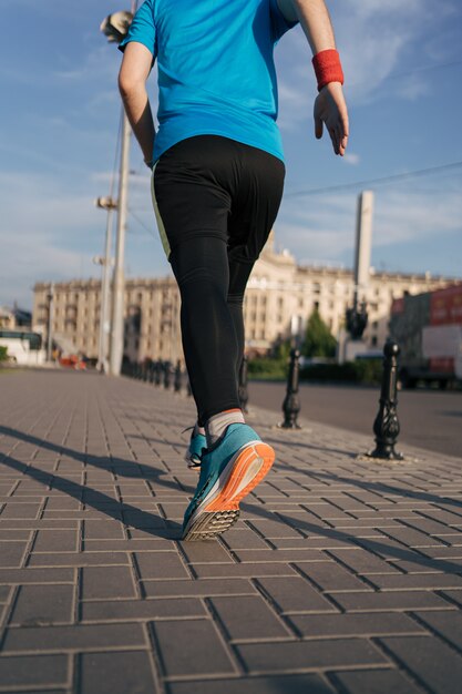 Hombre atractivo en forma corriendo en la ciudad