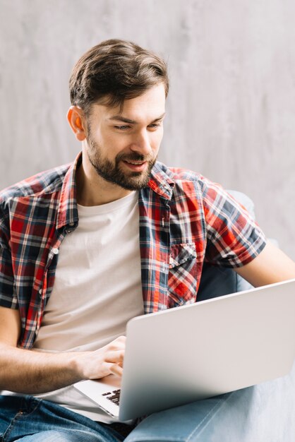 Hombre atractivo que usa la computadora portátil