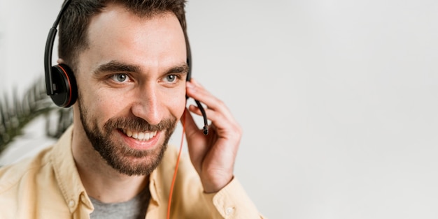 Hombre con auriculares asistiendo a clases online